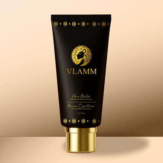 Black and gold tube of VLAMM hair balm on a beige background